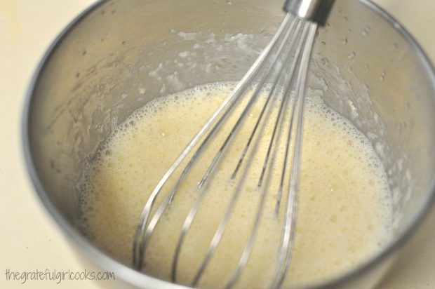 Egg, milk and butter with whisk in bowl