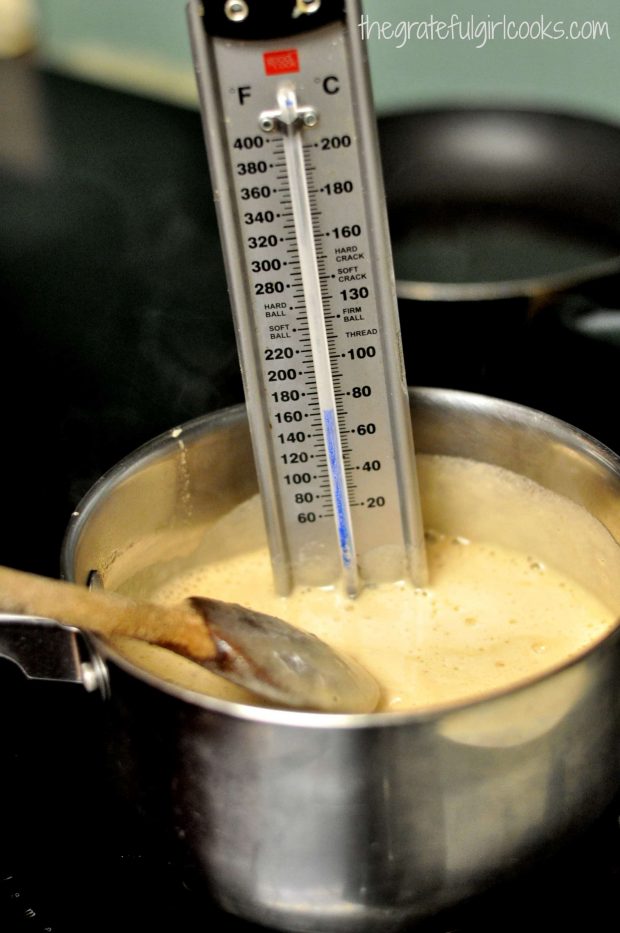 Candy thermometer in boiling sauce for bacon pecan pralines.