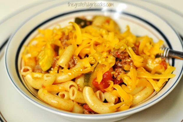 Chili mac is sprinkled with grated cheddar cheese to serve.