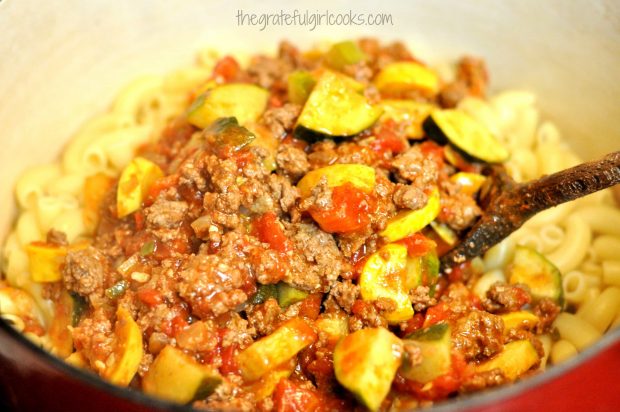 Pasta, beef and summer squash are stirred to combine.
