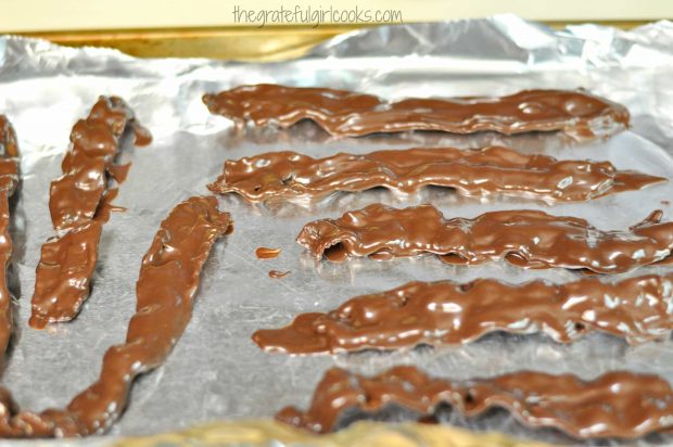 Chocolate dipped bacon is left to dry until chocolate firms up