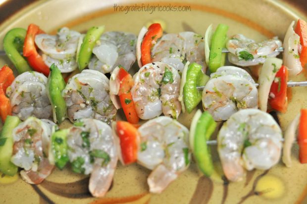 Shrimp kabobs are placed onto skewers before grilling.