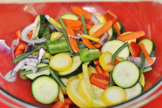 Cut veggies are placed in large bowl to mix with seasonings.