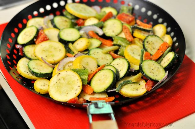 Veggies are placed into a BBQ-grill pan for cooking.