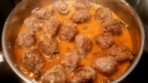 Cooked meatballs stroganoff with sauce in skillet.