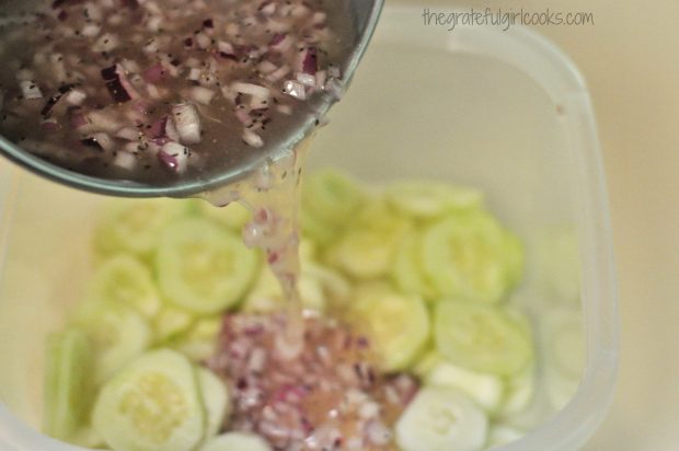 Marinade poured over sliced cucumbers in container