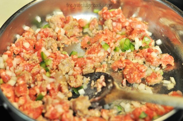 Chopped green peppers are added to sausage, and onions for spaghetti sauce.