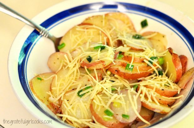 Grated Parmesan cheese is sprinkled on top of the hot potatoes.