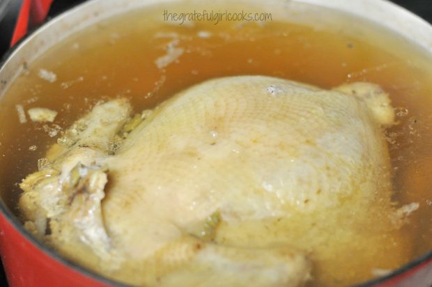 Whole chicken cooking in stockpot