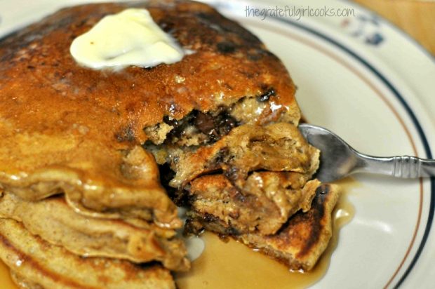 Cutting into the pumpkin chocolate chip pancakes with a fork.