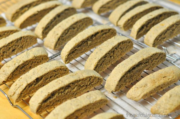 Baked biscotti slices, cooling on a wire rack.