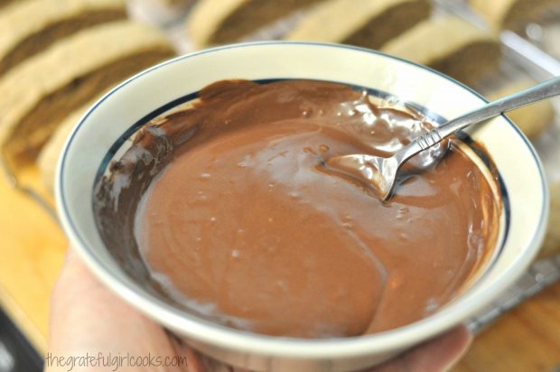 Chocolate is melted with shortening, to make a drizzle for topping the biscotti.
