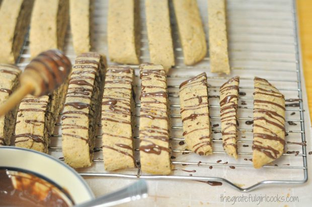 Melted chocolate is drizzled over the tops of the baked biscotti.