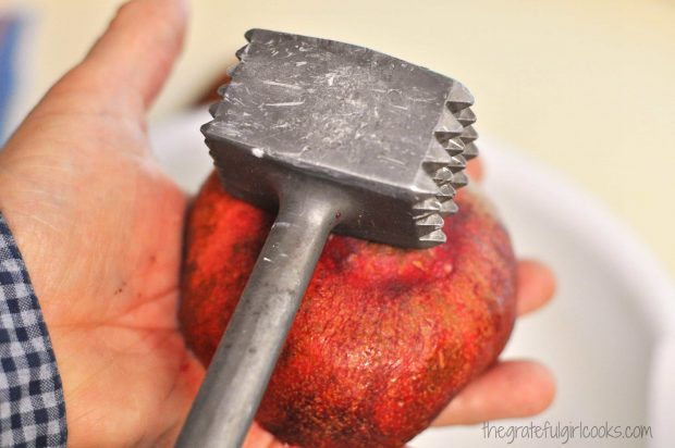 Use meat mallet to hit pomegranate.