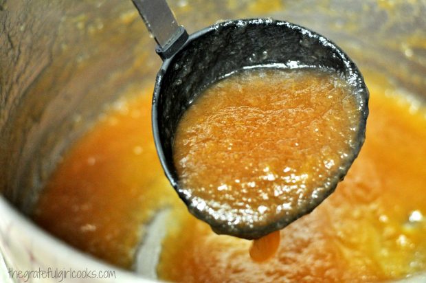 Ladle with hot apple butter dripping