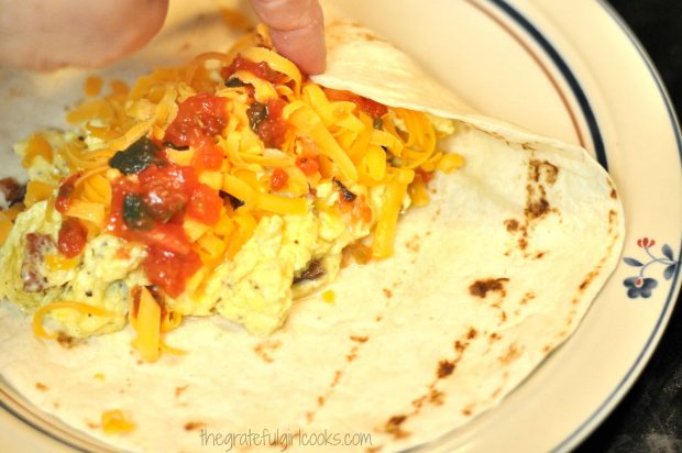Rolling up the tortilla around the filling, to make breakfast burritos.