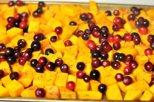 Fresh cranberries are added to roasted butternut squash, then placed back into oven.