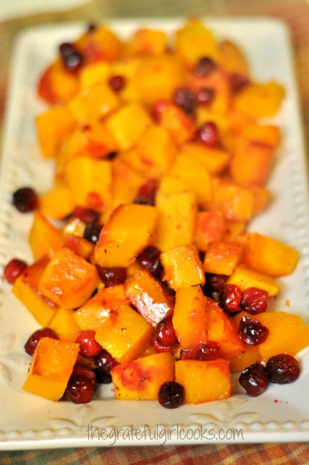 Roasted butternut squash and cranberries are removed from oven, and put on a serving platter.