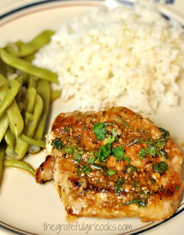 Seared pork shops, served with green beans and rice.