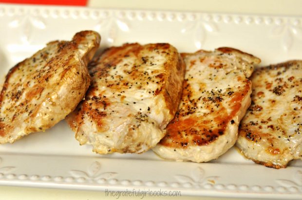 Seared pork chops are placed on serving platter.