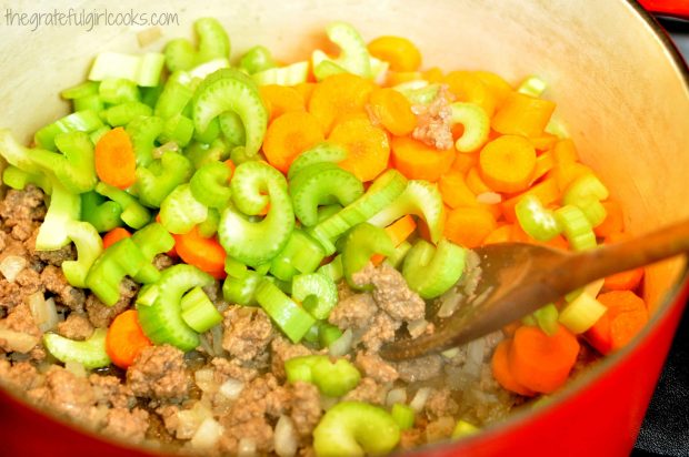 Celery and carrots are added to the soup pot.