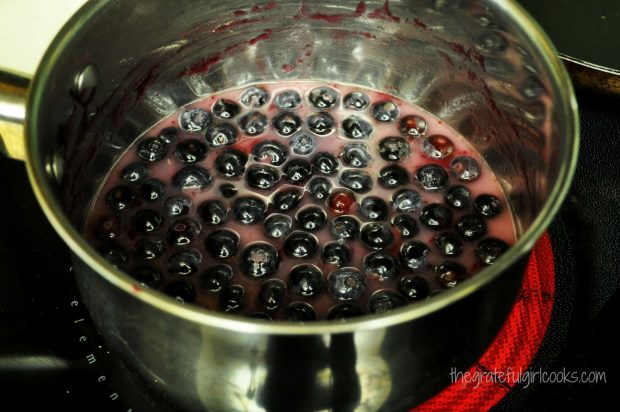 Blueberries are cooked in saucepan until thickened sauce is created
