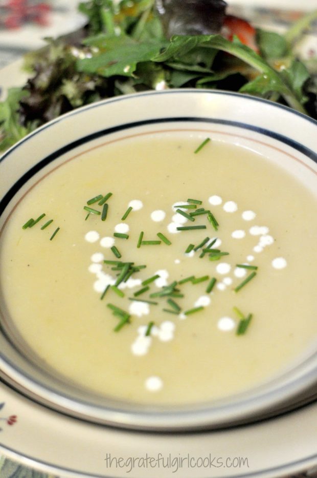 A bowl of creamy potato leek soup, with green salad on the side.
