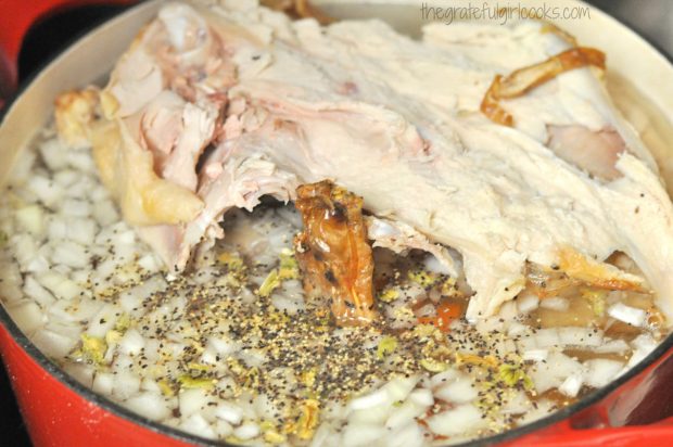 Turkey carcass is cooked with onions, celery and carrots in water to make creamy turkey wild rice soup.