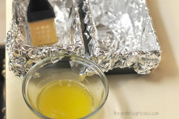 Mini loaf pans are lined with foil, then brushed with melted butter.