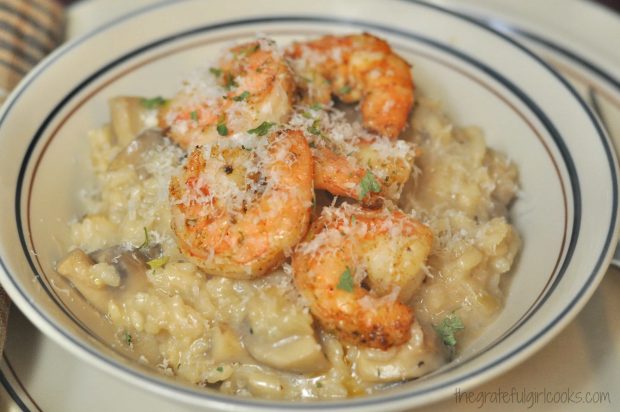 Creamy mushroom risotto served in bowl, with pan-seared shrimp on top