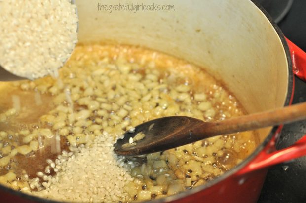 Arborio rice being added to red saucepan, for risotto