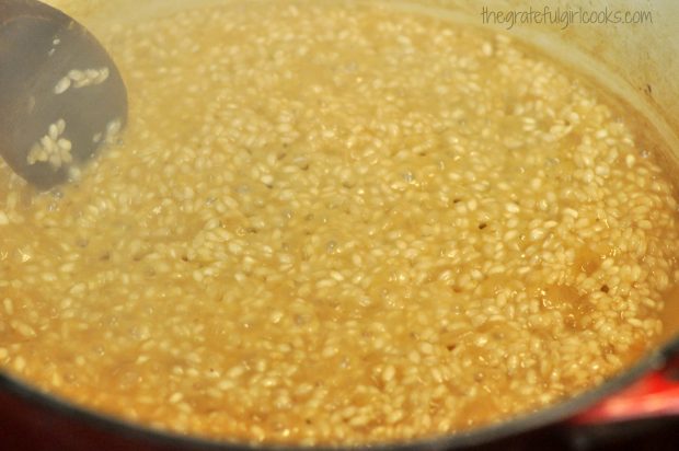 Wine and broth added to risotto mixture in pan