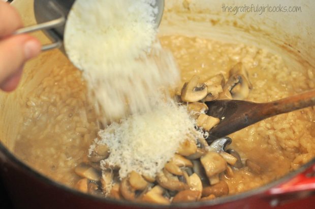 Parmesan cheese being added to risotto and mushrooms in pan