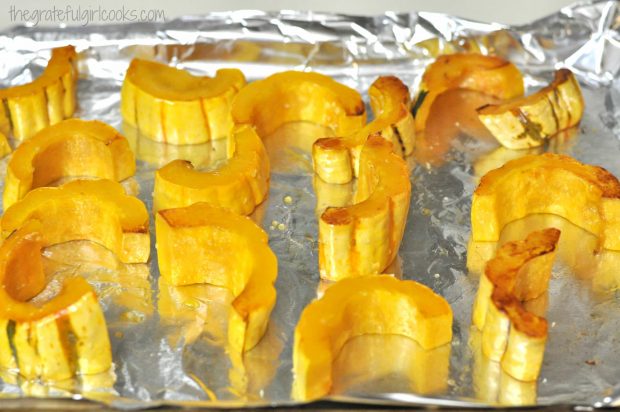 Roasted Delicata Squash slices are flipped over during the baking time to lightly brown both sides.