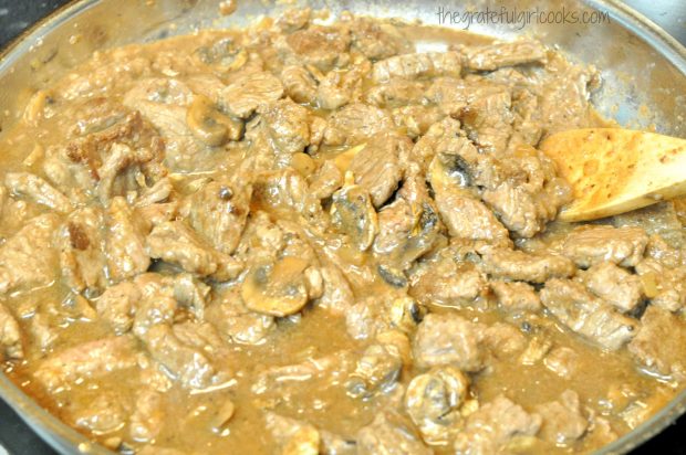 Beef stroganoff cubes added to skillet with sauce.
