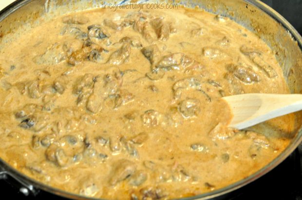 Heating sauce and meat for beef stroganoff in large skillet