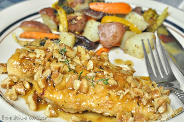 Chicken Cutlets With Pecan Sauce are served with roasted vegetables on the side.