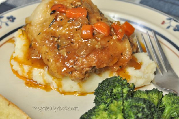 Chicken Thigh Osso Bucco served on top of potatoes, with broccoli on the side.