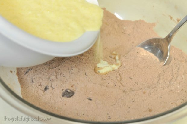Butter, egg and buttermilk added to chocolate almond chia muffins mix in bowl.