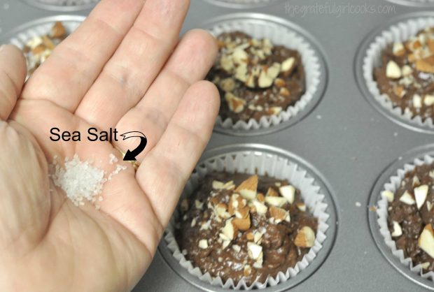 Sea salt is sprinkled on top of chocolate almond chia muffins before baking.