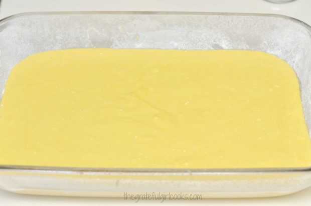 Lemon cake batter is poured into 13x9 inch baking dish.