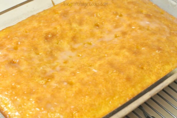 Lemon glaze is absorbed through the holes poked into cake.