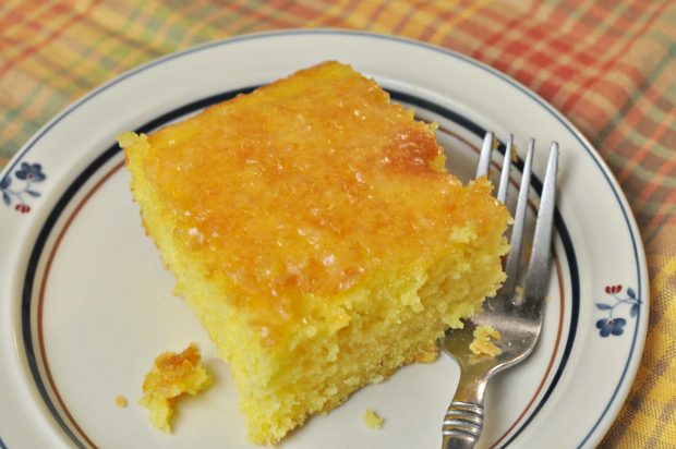 Slice of lemon cake on plate with a fork... ready to eat.