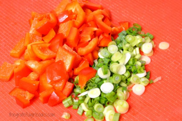 Red bell peppers and green onions are chopped to add to the sweet fire chicken.