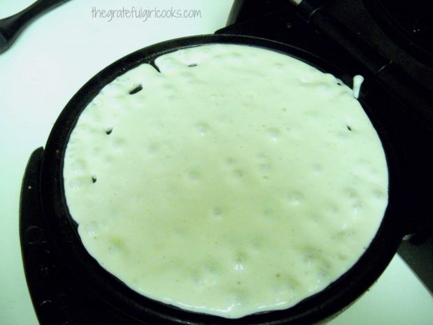 Cooking a waffle in a waffle maker.