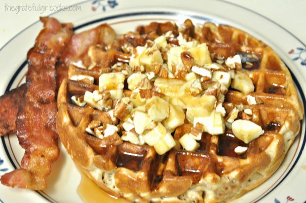 Banana Waffle with pecans and bananas, with bacon on side of plate