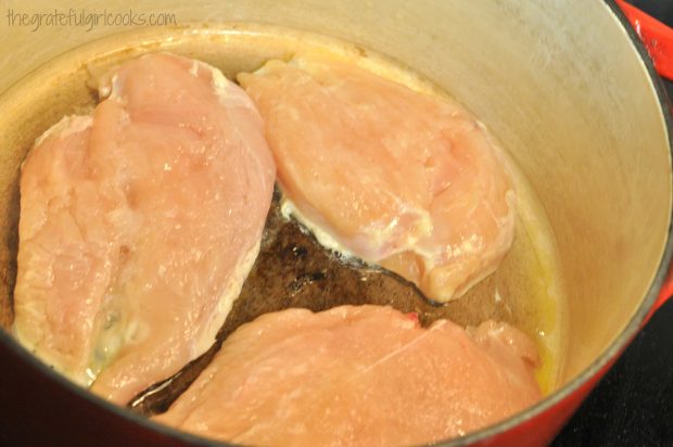 Chicken breasts cooking in large saucepan