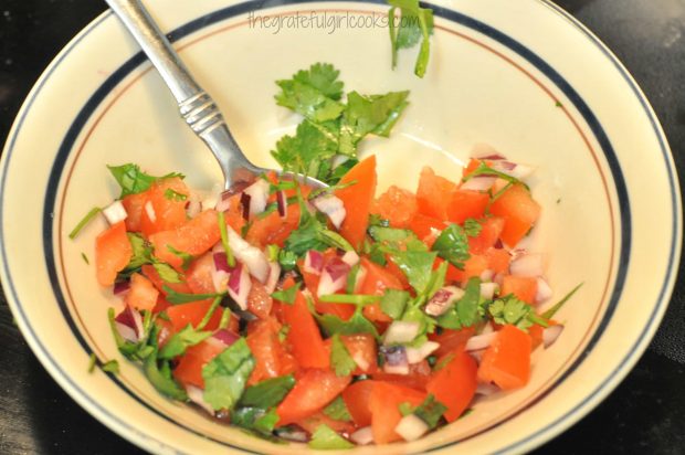 Pico de gallo is mixed together, to garnish Chili's chicken enchilada soup.