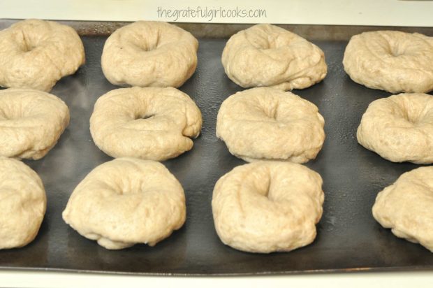 The cinnamon crunch bagels are drained then placed on baking sheet to cook in oven.