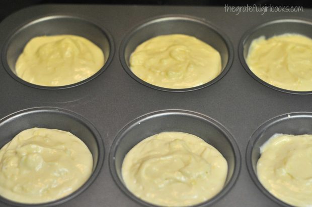 The batter is evenly divided into muffin tins.